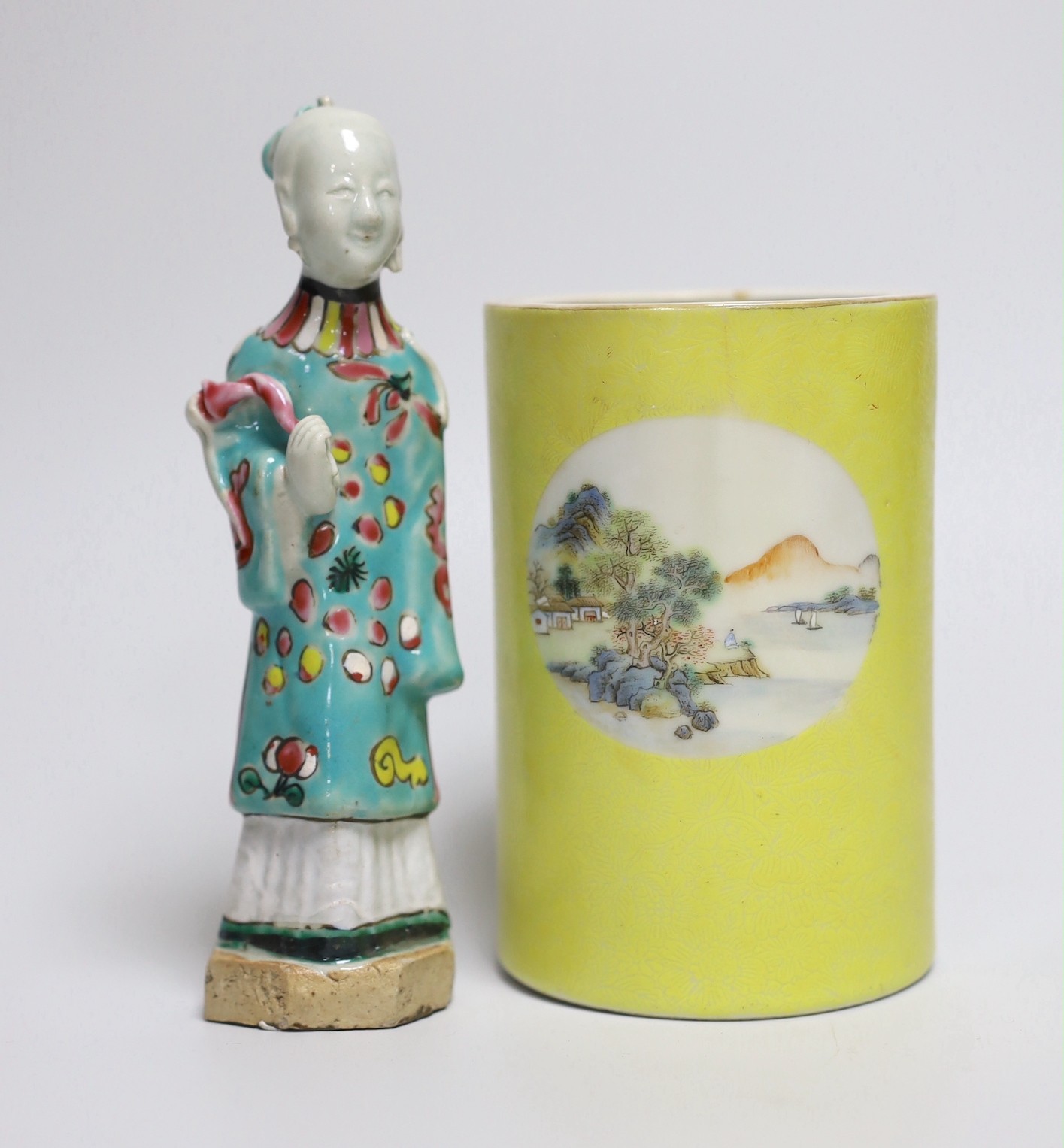 A Chinese yellow ground cylindrical brush pot, Republic period and a Jiaqing famille rose figure of a deity, tallest 16cm